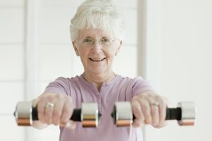 Senior woman lifting weights to help move.